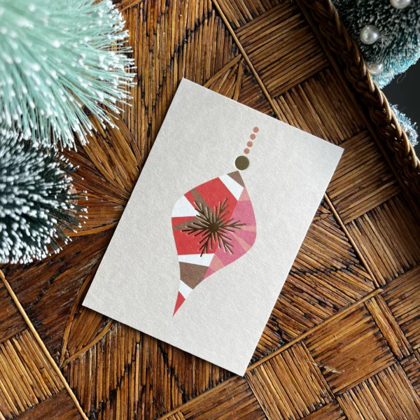 Kerstkaart met rode kersthanger en gouden folie