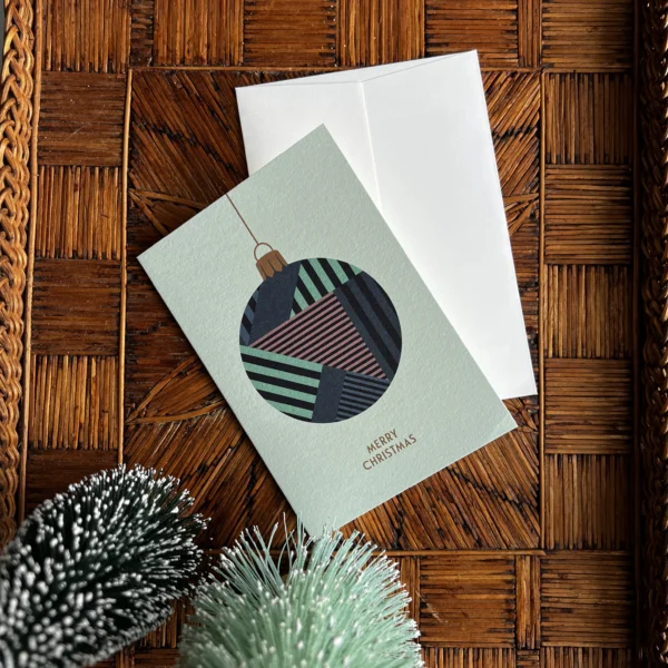 Moderne kerstkaart met groene kerstbal en X-Mas tekst